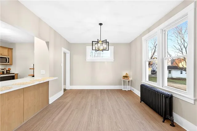 a hallway with a chandelier and wooden floor