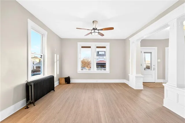 a view of an empty room with a window and wooden floor