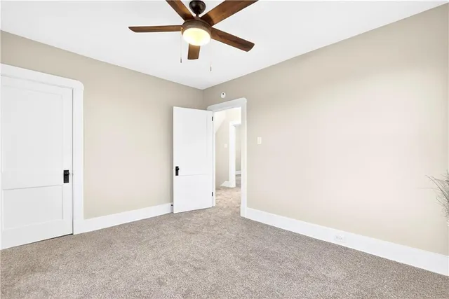 an empty room with chandelier fan