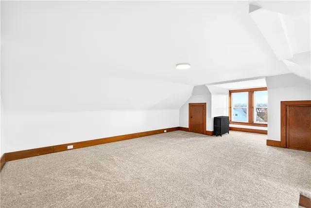 an empty room with fireplace and windows