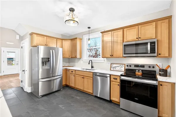 a kitchen with stainless steel appliances a stove a sink and a refrigerator
