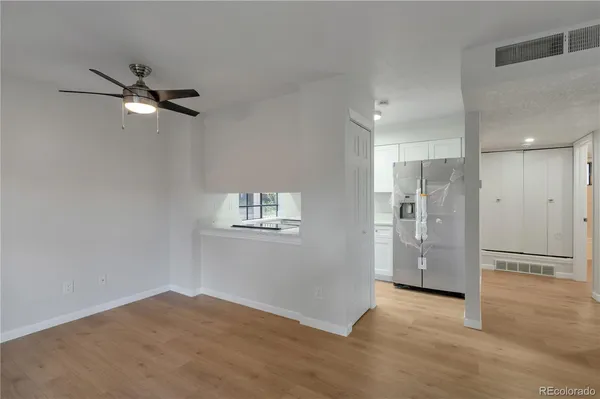 a view of empty room with wooden floor and ceiling fan