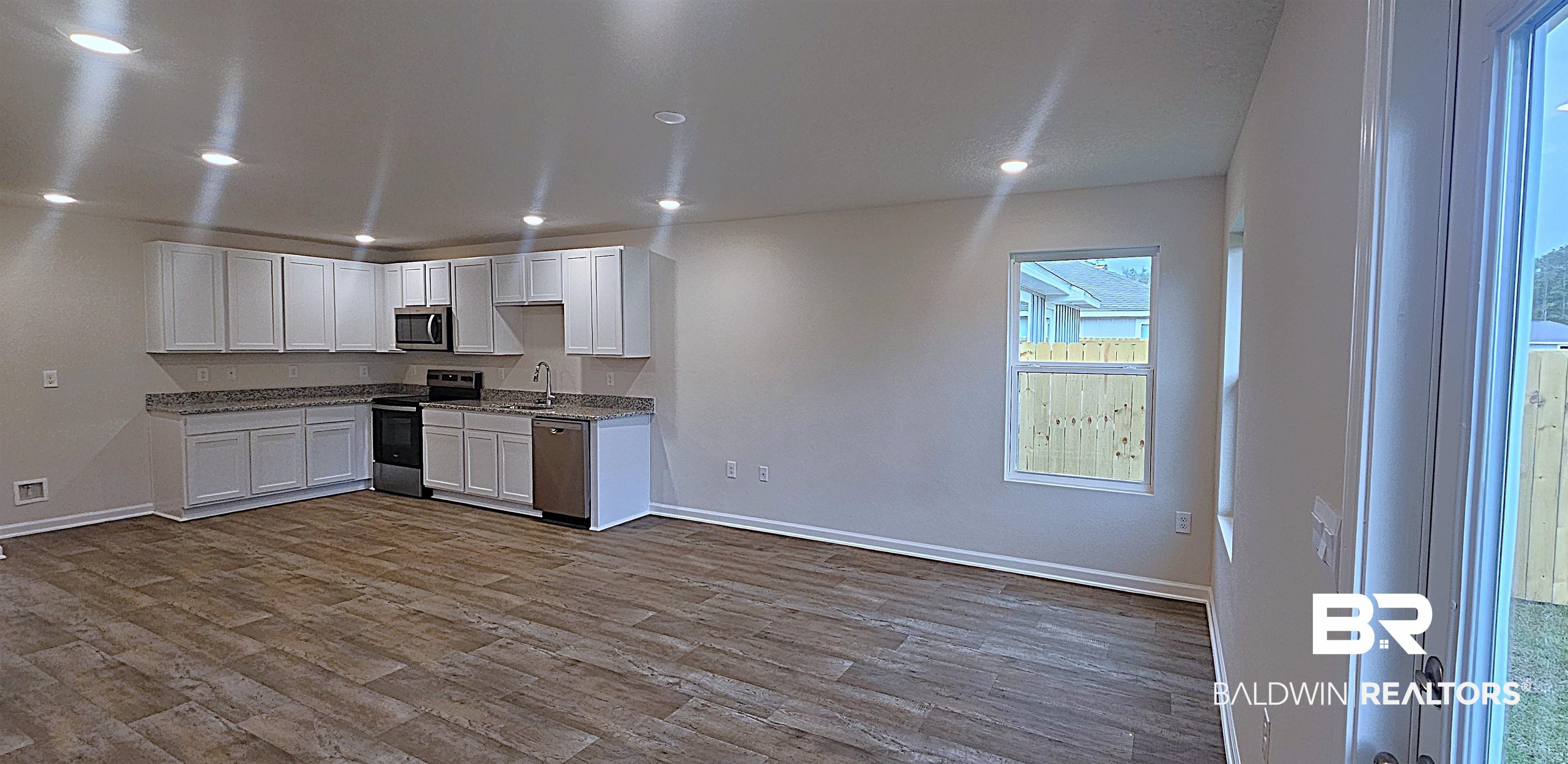 1148 Sweet Laurel Street Foley, AL 36535 - Photo 12 of 18 Kitchen with appliances with stainless steel finishes, light hardwood / wood-style flooring, white cabinets, and sink