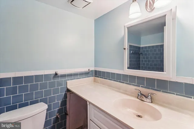 a bathroom with a sink a toilet and a mirror