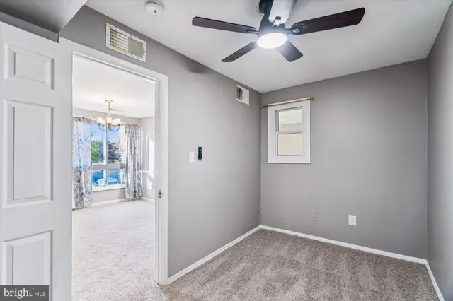 a view of a hallway with a livingroom and a chandelier fan