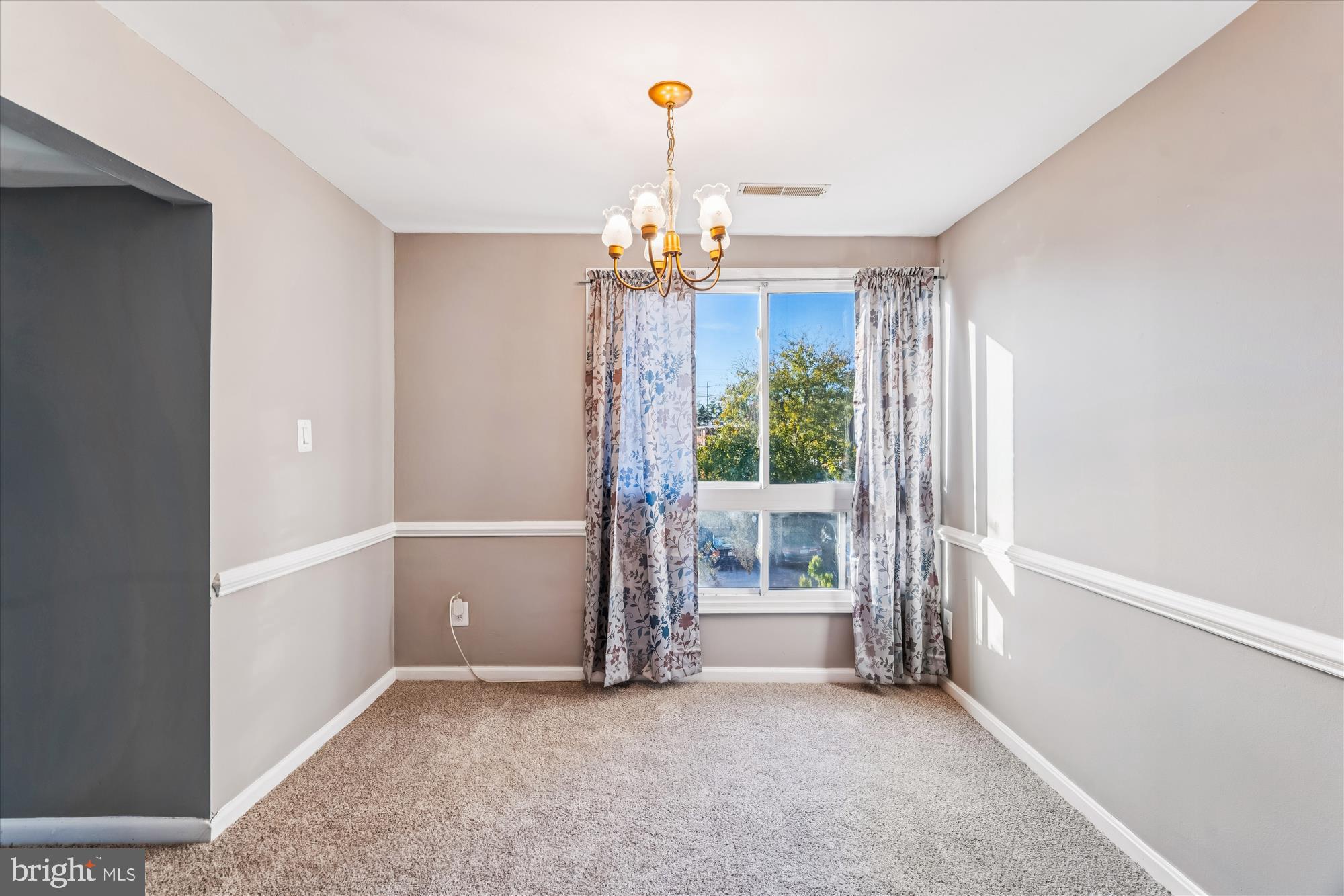 7973 Riggs Road, Unit 8 Hyattsville, MD 20783 - Photo 26 of 45 an empty room with chandelier fan and windows