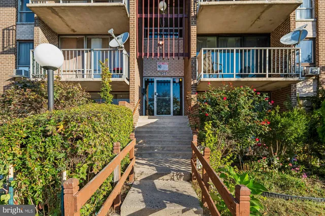 a view of a house with brick wall and flower plants