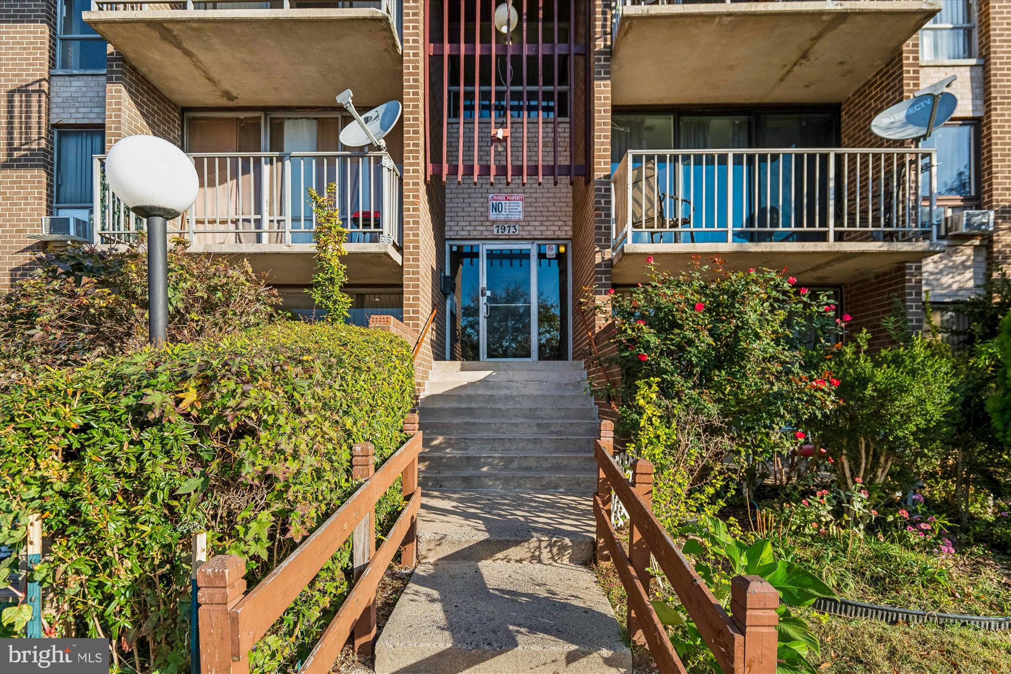 7973 Riggs Road, Unit 8 Hyattsville, MD 20783 - Photo 3 of 45 a view of a house with brick wall and flower plants