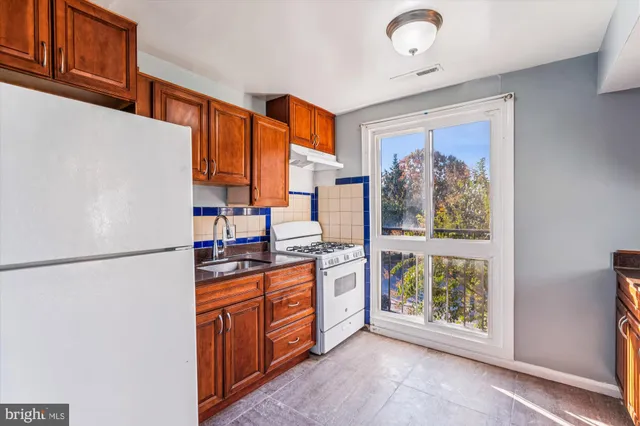 a kitchen with stainless steel appliances granite countertop a refrigerator and a stove top oven