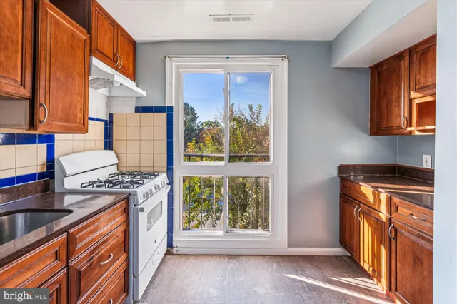 a kitchen with stainless steel appliances granite countertop a stove top oven