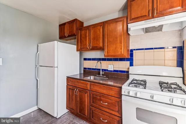 a kitchen with stainless steel appliances granite countertop a refrigerator sink and stove