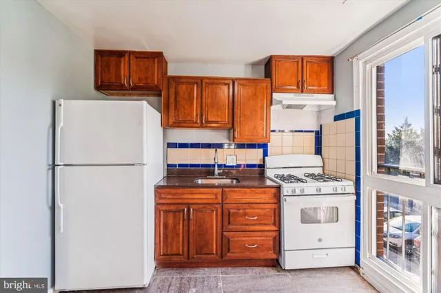 a kitchen with a refrigerator a stove top oven and a window