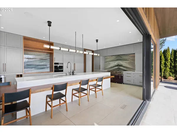 a open kitchen with stainless steel appliances kitchen island granite countertop a table chairs and a refrigerator