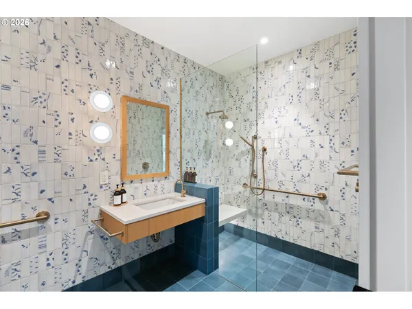 a bathroom with a sink mirror and a shower