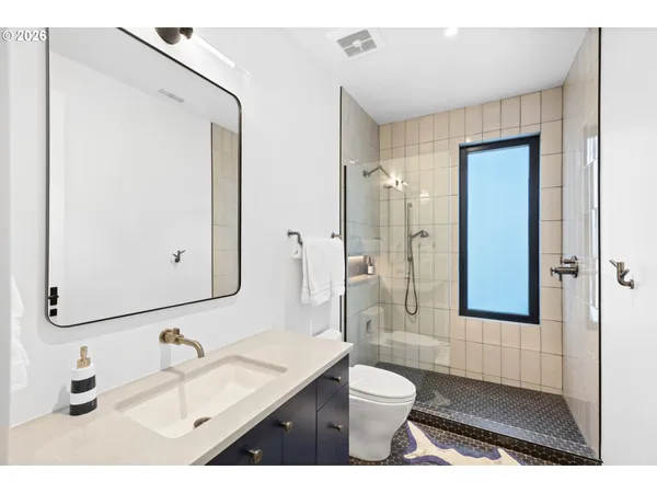 a bathroom with a sink a toilet and a mirror