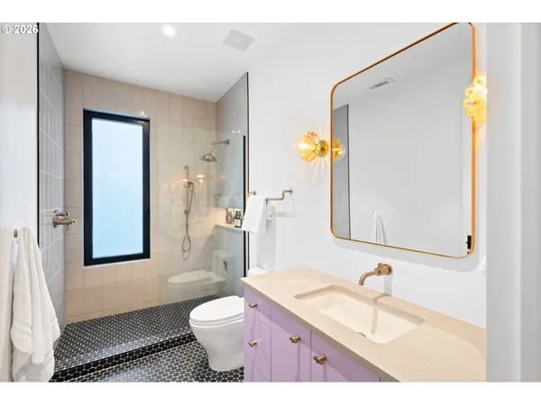 a bathroom with a granite countertop sink mirror vanity and toilet