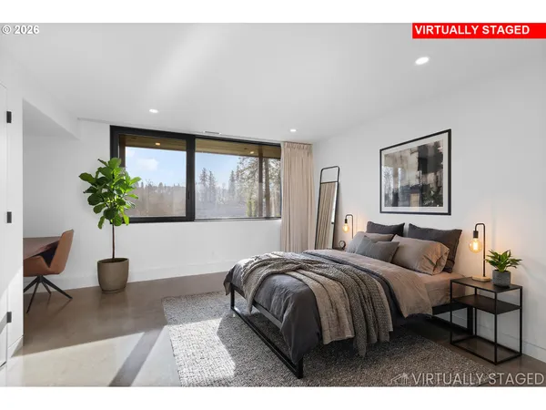 a bedroom with a large bed and a potted plant