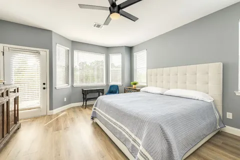 a bedroom with a bed and wooden floor