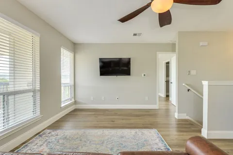 a view of a livingroom with wooden floor and a ceiling fan
