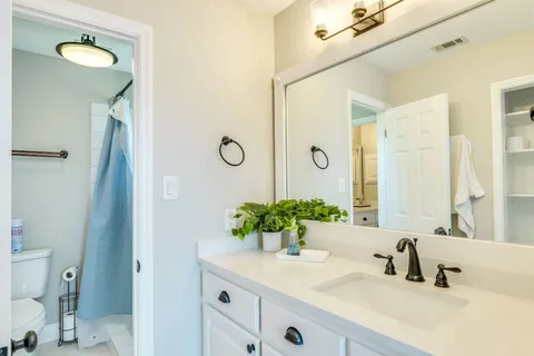 a bathroom with a granite countertop sink and a mirror
