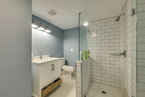 a bathroom with a sink a toilet and shower
