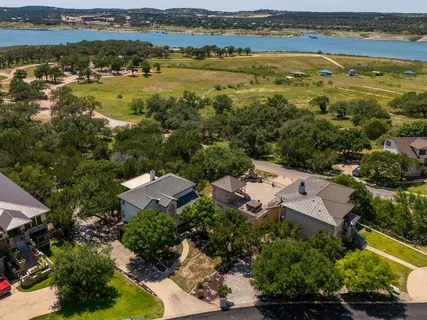 an aerial view of residential houses with outdoor space and lake view