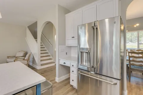 a kitchen with stainless steel appliances a refrigerator and white cabinets
