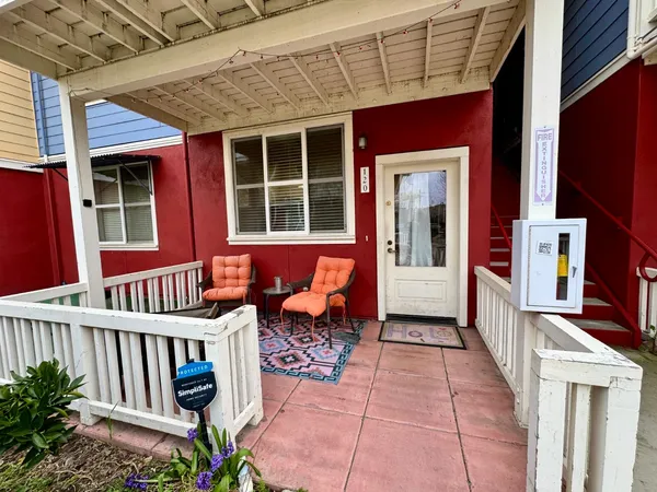 a view of front red door with a bench