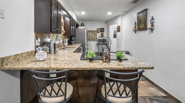 a kitchen with stainless steel appliances granite countertop a table chairs a stove and kitchen island