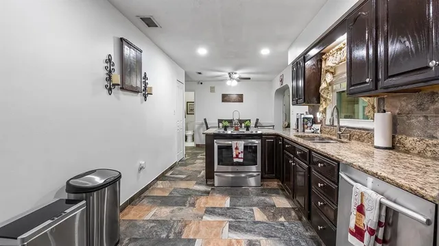 a kitchen with stainless steel appliances granite countertop a sink stove and refrigerator