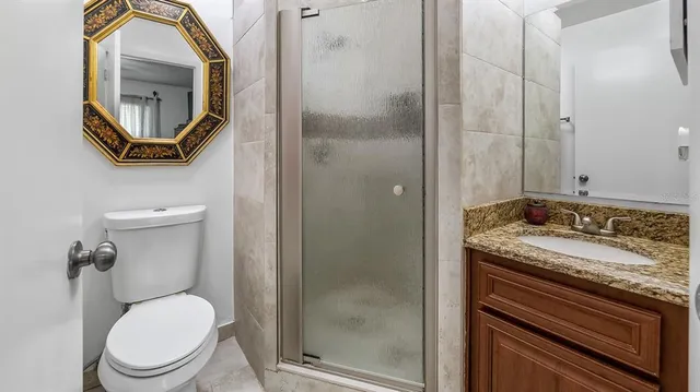 a bathroom with a granite countertop toilet sink and mirror