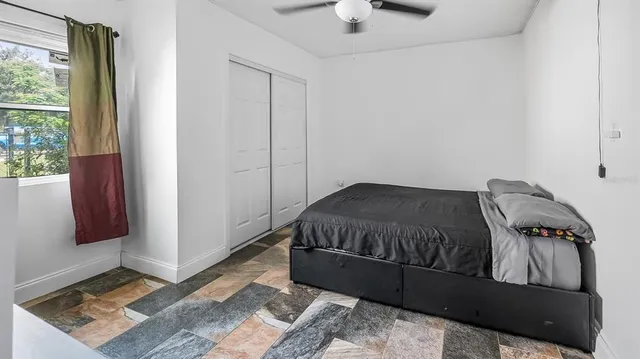 a bed sitting in a bedroom next to a window