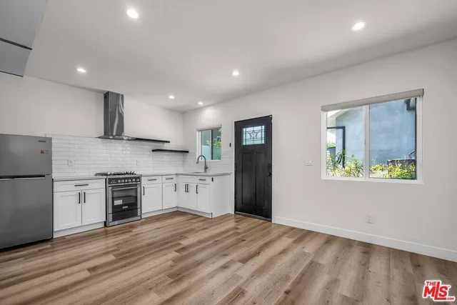 a kitchen with stainless steel appliances granite countertop a refrigerator and a stove top oven