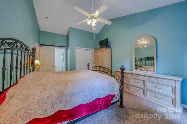 a bedroom with a large bed and a chandelier