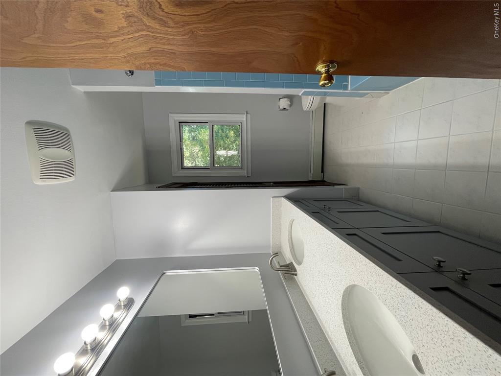 4 Cornwallis Road East Setauket, NY 11733 - Photo 8 of 16 a bathroom with a double vanity sink a mirror and a bathtub