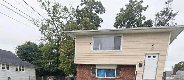 a side view of a house with a tree
