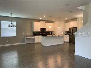 a large kitchen with stainless steel appliances granite countertop a large counter top a sink and a stove