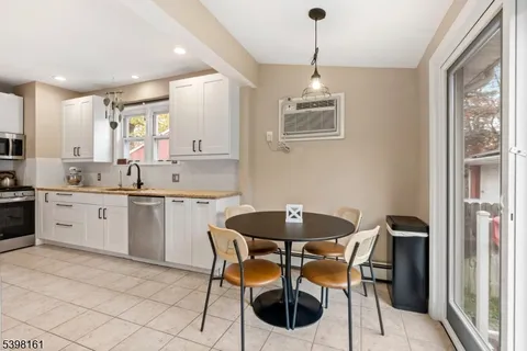 a kitchen with a dining table chairs and white cabinets