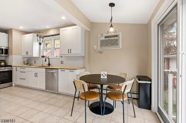 a kitchen with a dining table chairs and white cabinets