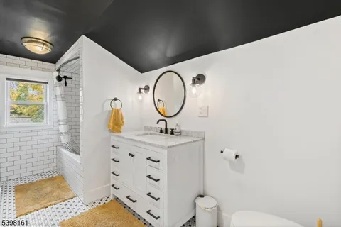 a bathroom with a sink mirror vanity and toilet