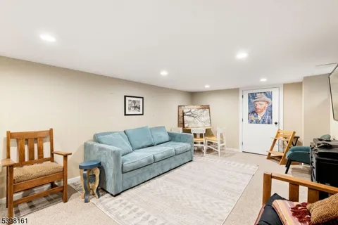 a living room with furniture and a flat screen tv with wooden floor