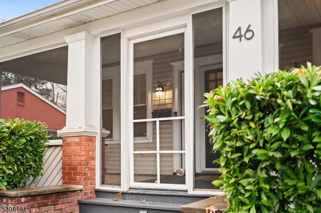 a view of a door of the house with a tree