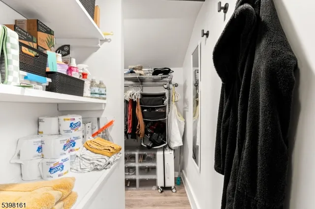 a view of walk in closet with clothes and shoes