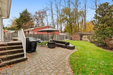 a view of a patio with a table and chairs under an umbrella
