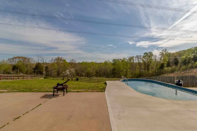 a view of a swimming pool and trees in the background