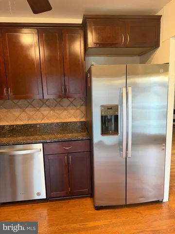 a view of a refrigerator in kitchen and wooden cabinets