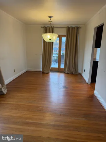 an empty room with wooden floor and a ceiling fan
