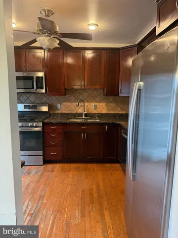 a large kitchen with stainless steel appliances granite countertop a sink and a stove