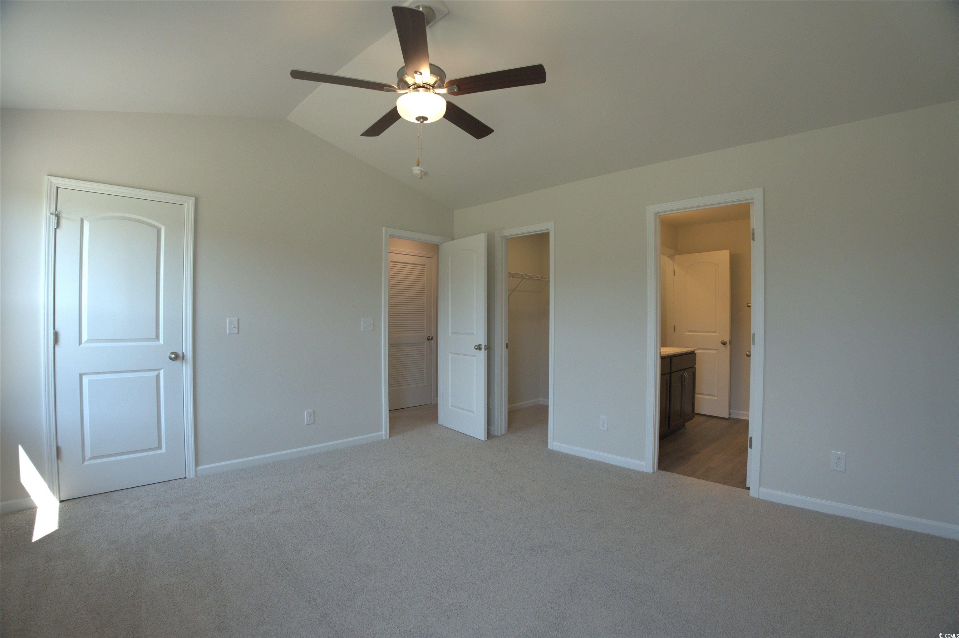 205 Kc Lane Aynor, SC 29511 - Photo 21 of 28 Unfurnished bedroom with a spacious closet, vaulted ceiling, carpet, and ceiling fan