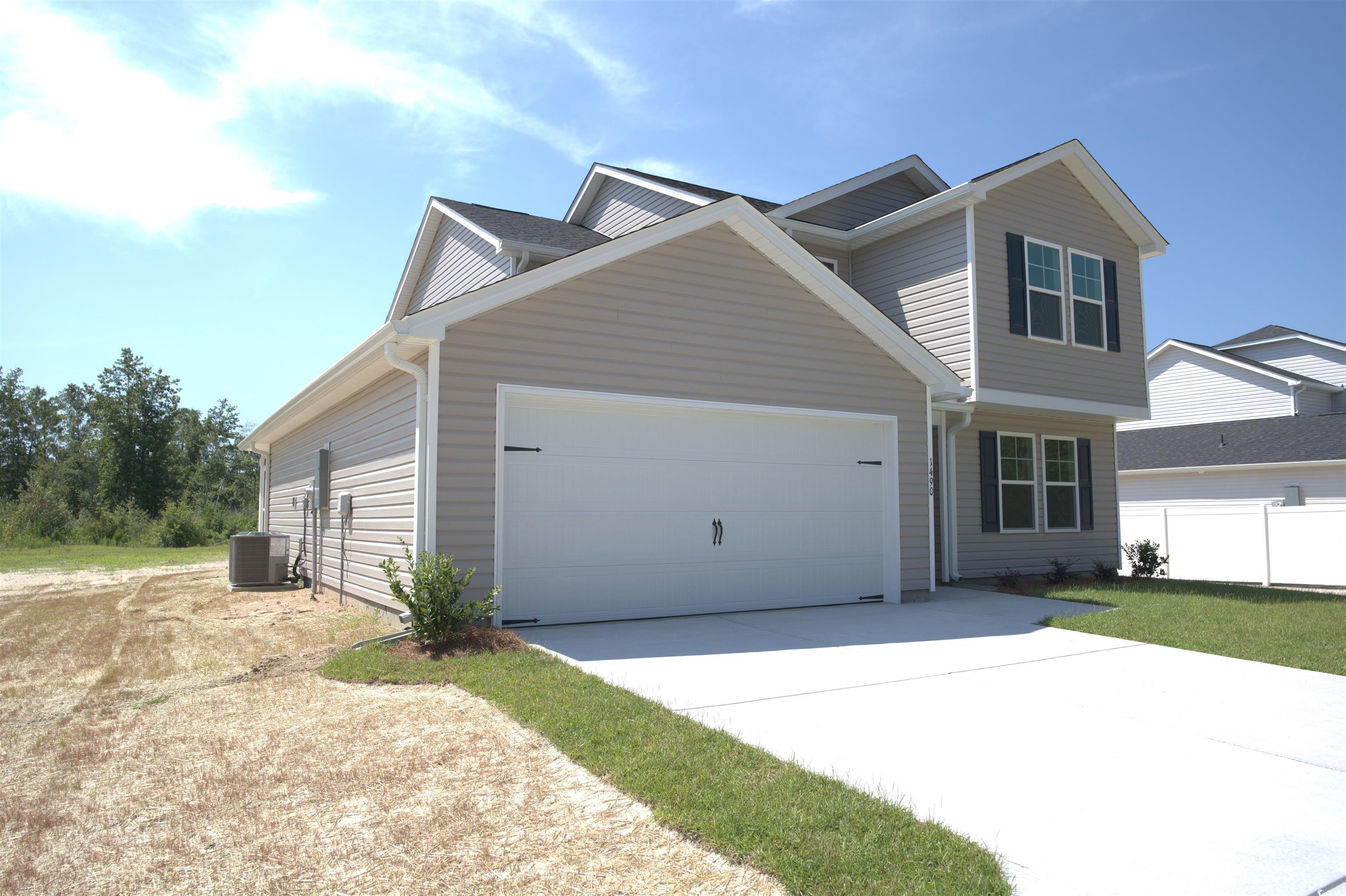 205 Kc Lane Aynor, SC 29511 - Photo 22 of 28 Unfurnished bedroom with light colored carpet, lofted ceiling, a walk in closet, ensuite bathroom, and a ceiling fan